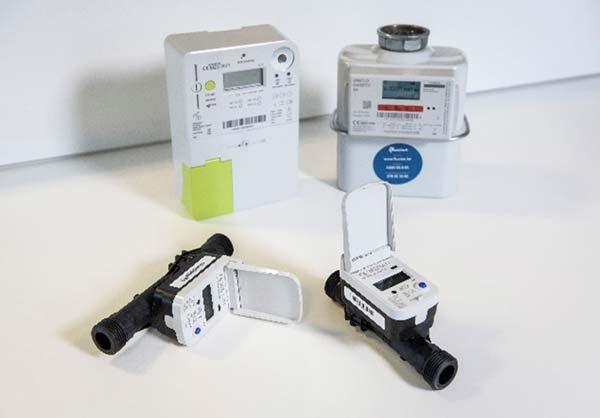 Figuur 9: ToF ultrasone watermeters (vooraan) die draadloos kunnen verbonden worden met een digitale elektriciteitsmeter (achteraan links). Achteraan rechts is een digitale gasmeter te zien. Bron: Fluvius.